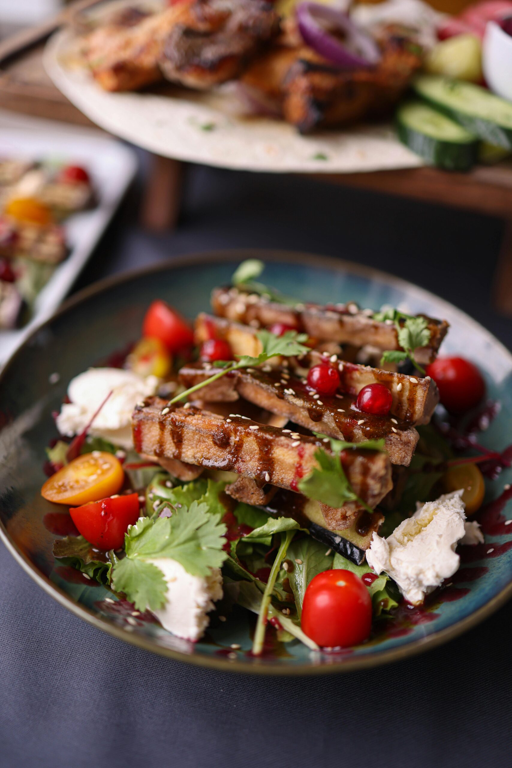 A plate of food with tomatoes, cheese and salad